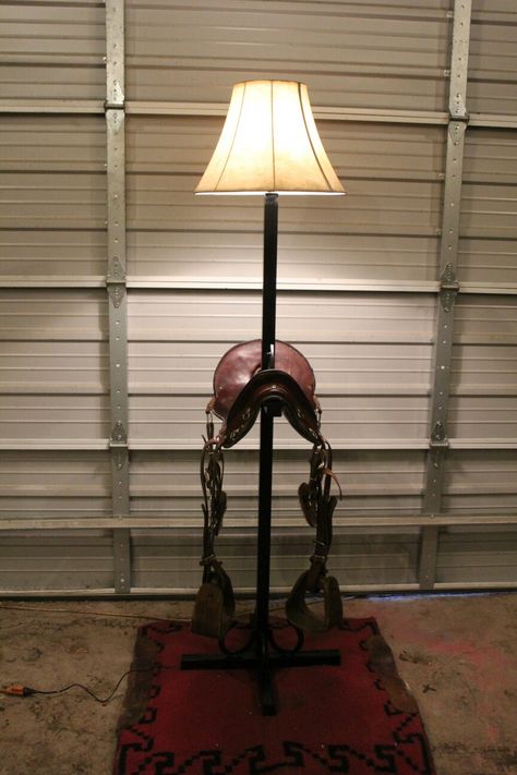 This beautiful, hand crafted piece is a standing lamp made with an authentic calvary saddle! Accessorized with horse shoes and a rustic style lampshade to bring it all together to make a lovely one-of-a-kind lamp.  From the beautiful cherry color of the saddle to the old wooden stirrups, it is truly gorgeous for any office or living space.  This lamp is made out of 14 gauge steel and is welded solid.  $300.00  Located in Wheatland, Missouri www.facebook.com/ArrowNRanch Western Ideas, Standing Lamps, Cherry Color, Horse Shoes, Brass Lamp, Standing Lamp, Stirrups, Beautiful Lamp, Bring It