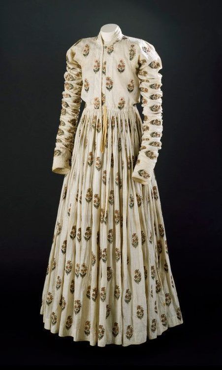 Late Mughal Period costume: Man’s robe of white cotton, with repeating staggered pattern of embroidered floral motifs in gold-wrapped thread and floss silk. Long sleeves, front opening, floor-length gathered skirt – 18th century, India. Indian Men Fashion, Period Costumes, Historical Dresses, India Fashion, Historical Clothing, Historical Fashion, Fashion History, Indian Outfits, Anarkali