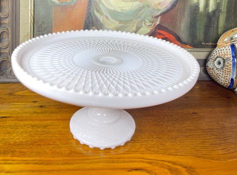 Pleas read full description below and see all photos!  This is a GORGEOUS soft/pale Shell pink Jeannette Glass milk glass footed/pedestal cake stand.  There is a manufacturing defect on the hobnail rim, which gives it some character - the plate when made had some sort of residue in the mold and that transferred to the tips of some of the rim (see photos) they look almost like small "burn" marks. No chips, cracks or repairs.  Jeannette in the 1950/60's rarely had a hallmark, this piece does not. Pink Milk Glass, Milk Glass Collection, Pedestal Cake Stand, Pink Milk, Top Base, Shell Pink, Glass Molds, Cake Stands, Cake Servings