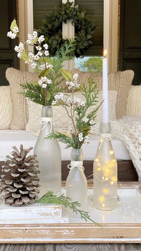 DIY frosted glass bottles with winter greens, white berries, taper candles, and fairy lights in them. Christmas Glass Bottles Diy Projects, Wine Bottle Diy Decor, Frosted Wine Bottle Centerpieces For Wedding, Glass Bottle Ideas Decoration, Recycling Glass Bottles, Upcycling Glass Bottles, What To Do With Glass Bottles, Glass Bottle Crafts Home Decor, Glass Bottle Decor Ideas