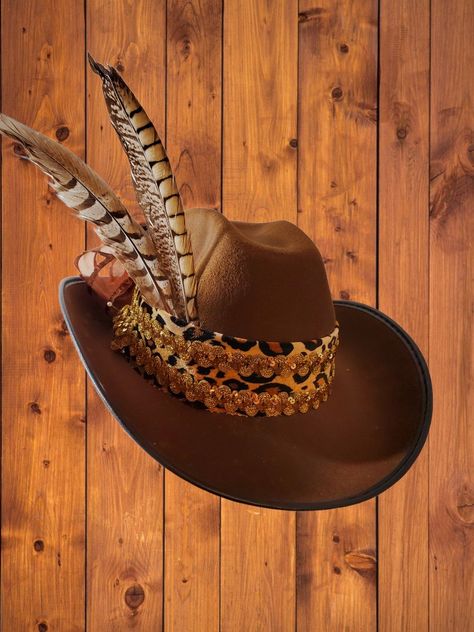 Cowgirl hat in mocha with leopard velvet band, gold sequined braid, pheasant feathers and sheer ribbon bow at the back. Sassy! Cowboy Hat Crafts, Cowboy Hat Design, Brown Cowboy Hat, Sequin Hat, Glam Boho, Custom Cowboy Hats, Classy Hats, Custom Made Hats, Western Cowboy Hats