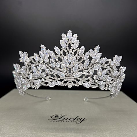 Unleash your inner queen with our Quinceanera Crown Tiara! Perfect for weddings, pageants, and special occasions, this headpiece will make you stand out with its brilliant shine. Own your look and claim your crown with confidence and style. High Quality Marquise and Round CZ gems. Measures 2 1/4 inches central height tapering to 1 inch to the sides Handcrafted with highest quality Zirconia jewels and rhodium plated to prevent tarnish and scratch. Ideal for Wedding, Bridal Hair, Anniversary, Quinceanera, Prom, Pageant and Special Occasions. Each Lucky Collections ™ tiara comes in custom luxury box for convenient presentation and keepsake. Loops on both ends of the Headpiece for stability and security Fast and Free Shipping from Los Angeles, California. Quinceanera Crowns Tiaras, Quinceanera Crown, Wedding Bridal Hair, Pageant Crowns, Bridal Jewelery, Beautiful Tiaras, Crown Tiara, Bodo, Crystal Crown