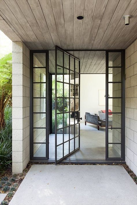 https://archinect.com/news/article/150142511/10-beautiful-door-designs-we-liked-this-week Modern Front Entry, Steel Pivot Door, Marmol Radziner, Flat Door, Exterior Entry Doors, Pivot Door, Iron Red, Pivot Doors, Stair Steps