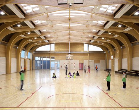 The gymnasium Regis Racine is situated in Drancy north east Paris. the program of this building includes: an indoor sports hall 22 meters long and 44 meters large, a dance hall, a space for local associations and dressing rooms for teams and referees. It was designed for pupils of schools and... Gym Architecture, Sports Facility Architecture, School Hall, Indoor Basketball Court, Paris Atelier, Timber Architecture, Timber Roof, Wood Architecture, Sport Hall