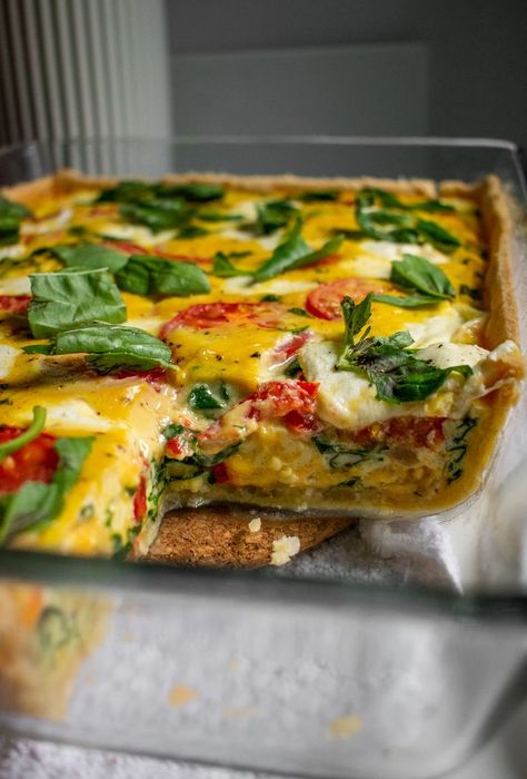 A quiche in a large pan with a slice cut out. Caprese Quiche Recipes, Quiche Tomato, Mozzarella Quiche, Caprese Quiche, Bake Savory, Spinach Mozzarella, Tomato Quiche, Tomato Spinach, Spinach Quiche