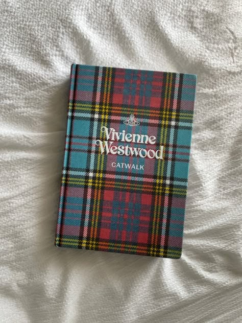 Vivienne Westwood catwalk book laying on a white bedsheet Catwalk Books Aesthetic, Vivienne Westwood Catwalk Book, Book Fashion, Catwalk Books, Vivienne Westwood Book, Fashion Books Aesthetic, Fashion Book, 100 Books To Read, Dream Book