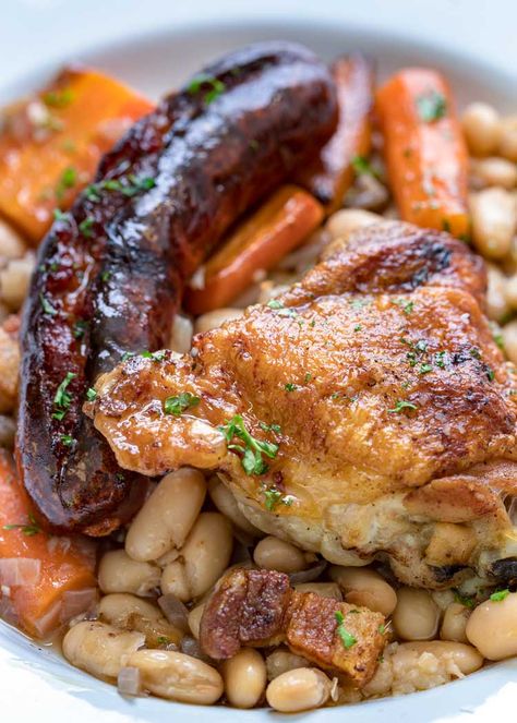 This comforting French Cassoulet recipe has juicy chicken, sausage, bacon and white beans that simmer away in a broth spiked with onion, garlic and herbs. #casserole #dinner #French #cassoulet French Recipes Appetizers, Cassoulet Recipe Easy, French Cassoulet Recipe, French Cassoulet, Cassoulet Recipe, French Recipes Authentic, French Cuisine Recipes, French Cooking Recipes, Fried Pork Belly