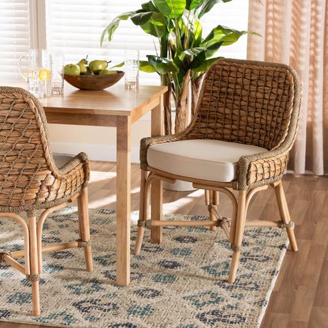 Bestow an air of ease to your space with the calm, soothing tones of the Kyle dining chair. Made in Indonesia, this chair is comprised of natural rattan semi pole frame embellished with handcrafted seagrass weave. Its seat features a removeable fabric upholstered cushion for outstanding comfort. The Kyle will arrive fully assembled and utilizes angled legs connected by a crisscross base for excellent stability and support. Capturing the luxurious comfort of a tropical escape, the Kyle dining chair elevates the mood of any arrangement. Due to the nature of the natural materials used in this product, it may have variations in areas such as, but not limited to, color, pattern, grain and texture. Bali & Pari Lakehouse Design, Boho Dining Chairs, French Country Dining Chairs, Dining Room Cozy, Tufted Dining Chairs, French Country Dining, Wicker Dining Chairs, Rattan Dining, Rattan Dining Chairs