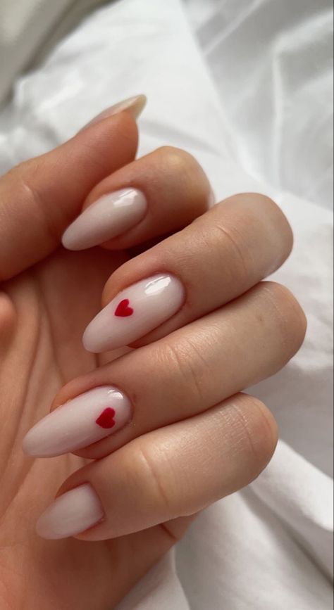 Off White Valentines Nails, Milky Nails With Heart Design, Valentine White Nails, Minimalist Nails Milky White, White Almond Nails With Red Heart, Oval Nails With Hearts, White With Hearts Nails, White Nails For Valentines Day, Valentines Day Nails Milky White