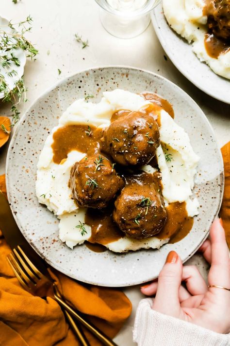 These Thanksgiving Meatballs taste just like a classic turkey dinner – in meatball form! Season ground turkey with sage, thyme, rosemary, & garlic, then shape into balls around Stovetop stuffing for next-level Thanksgiving flavor. Bake the turkey stuffing meatballs, finish in gravy, & serve over creamy mashed potatoes. Perfect for a small-scale Thanksgiving or an untraditional Friendsgiving dinner! #thanksgivingmeatballs #thanksgivingmeatballsappetizer #stuffingmeatballs #turkeystuffingmeatballs Season Ground Turkey, Turkey Stuffing Meatballs, Thanksgiving Meatballs, Stuffing Meatballs, Low Carb Turkey Meatballs, Stovetop Stuffing, Meatballs Turkey, Turkey Meatball Soup, Thanksgiving Mains