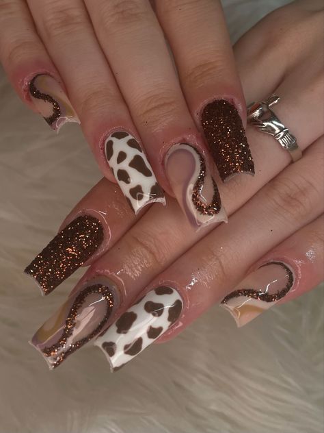 rown nails, brown glitter nails, cow print nails, brown nails, fall nails, luxury nails, sugar glitter nails, swirl nails, trendy nails, square nails, 2023 nails, y2k nails, nail art, nail inspo, gelx nails, gel extensions, baddie nails, hand painted nails, nail artist, brown swirl nails, abstract nails, nail set, funky nail set, nail set inspo, detailed nail art Cow Fall Nails, Fall Nails Cow Print, Brown Western Nails, Brown Nails With Rhinestones, Y2k Fall Nails, Cow Print Nails Brown, Square Nails 2023, Brown Swirl Nails, Sugar Glitter Nails