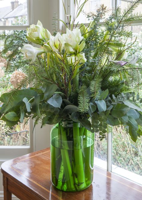 Christmas flower arrangement with fresh seasonal greens and white amaryllis.  Created by Butter Wakefield Christmas Flower Centerpieces, Flower Arrangements Green, Amaryllis Arrangement, Simple Arrangements, Eucalyptus Arrangement, Pine And Eucalyptus, White Amaryllis, Fresh Flower Arrangements, Christmas Greens