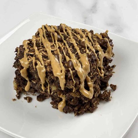 A serving of chocolate peanut butter oatmeal bake on a plate topped with a drizzle of peanut butter. Peanut Butter Oatmeal Bake, Chocolate Peanut Butter Oatmeal, Oatmeal Bake, Food Dolls, Baked Breakfast Recipes, Peanut Butter Roll, Baked Oatmeal Recipes, Peanut Butter Oatmeal, Peanut Butter Lovers