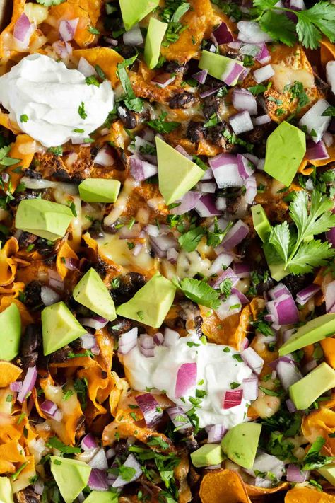 Easy loaded nachos with sweet potatoes and black beans are a healthy nacho recipe. These vegetarian nachos are gluten-free. An easy game day snack and the perfect balance for sweet and salty. Healthy Nacho, Sweet Potatoes And Black Beans, Black Bean Nachos, Nacho Recipe, Healthy Nachos, Bean Nachos, Vegetarian Nachos, Potato Nachos, Sweet Potato Nachos