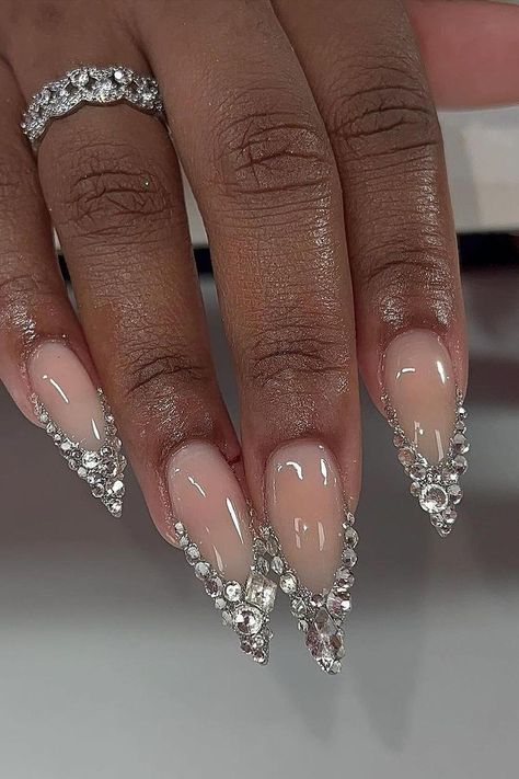 Stiletto nails making a statement with their luxurious crystal embellishments. The nude base provides a classic, understated canvas, allowing the sparkling rhinestones to truly shine, adding a touch of glamour to any look. Stunning and sophisticated! 💎✨  // Photo Credit: Instagram @bcollectivemag Nails 777, 777 Design, Stiletto Shaped Nails, Pink Stiletto Nails, Cute Simple Nails, Holiday Nail, Pearl Nails, January 3, Diamond Nails