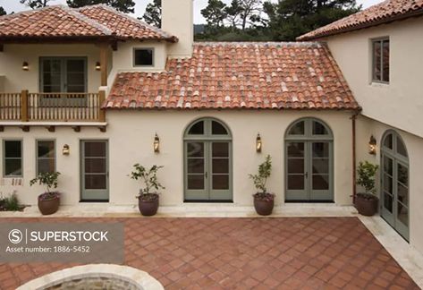 Exterior of a SPANISH STYLE LUXURY HOME with stucco walls a red tile roof and MEXICAN TILE PATIO - SuperStock Spanish Colonial Exterior, Terracotta Roof House, Pergola Vines, Red Tile Roof, Tile Paint Colours, Spanish Patio, Exterior Front Door Colors, Green Exterior House Colors, Red Roof House