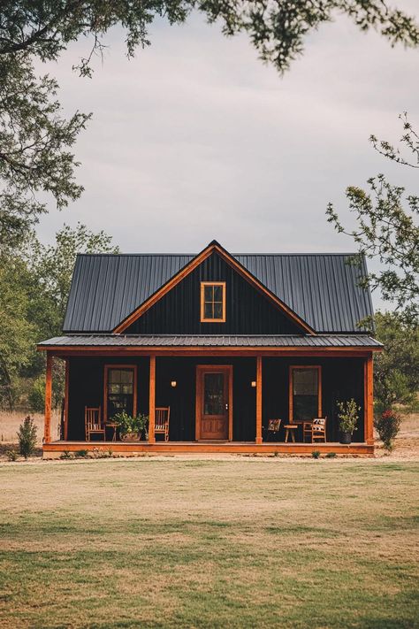 Charming wooden house with a metal roof and front porch. Saddle up your creativity with simple barndominium ideas that blend rustic charm with modern comforts for a home that’s as practical as it is eye-catching. Metal Roof Small House, Metal Cladding House Exterior, Simple Barndominium Ideas, Simple Barndominium, Black Metal Roof, Metal Roof Houses, Cabin Retreat, Farmhouse Architecture, Barn Style House Plans