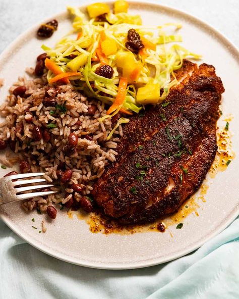 Jamaican Jerk Fish on a plate with Jamaican Slaw and Coconut Rice & Beans Jamaican Slaw, Jerk Fish, Carbs Meals, Christmas Seafood, Salad With Cabbage, Jamaican Stew, Meal Portions, Jamaican Rice And Peas, Monthly Meals