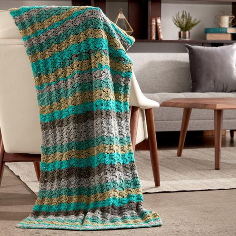 Create the most gorgeous summer afghan you will ever see. The Seaside Caron Cakes Afghan Pattern features gorgeous beach hues and the shell stitch. Use yarn cakes to get the soft, stripey color changes that are reminiscent of the beach! Shades of sand, brown, teal, and blue all grace this elegant afghan. The shell stitch is the perfect stitch to crochet the look of waves! If you're looking for a housewarming present for your friend's new summer home, this is the perfect project to make. Caron Cakes Patterns, Wave Blanket, Wavy Crochet, Afghan Crochet Patterns Easy, Caron Cakes, Easy Crochet Projects, Afghan Patterns, Crochet Afghans, Crochet Borders