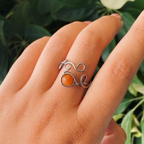 🍂Flower Crown Ring🍂 In the colors of fall and with the design resembling of vines, this ring is coming to life to adorn your fingers and brink a little bit of magic in your world🌿 Stainless Steel wire wrapped ring with a beautiful, vibrant, Carnelian crystal bead🔮 🍂DM for details🍂 . . #stainlesssteel #handmade #jewelry #handmadejewelry #handmadejewellery #fantasyjewelry #crystals #mystical #ring Colors Of Fall, Carnelian Crystal, Wire Wrapped Ring, Crown Ring, Wire Wrapped Rings, Stainless Steel Wire, Fantasy Jewelry, Flower Crown, Crystal Beads