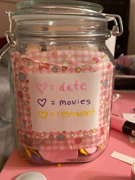 A mason jar with a  paper label, stuck on with pink gingham washitape. At the top, “pink heart = dates”, then “purple heart =  movies”, and finally “yellow heart = restaurant”. Kawaii Date Ideas, Jar Aesthetic, Dates In A Jar, Date Jar, Me And My Girlfriend, Night Jar, Date Night Jar, 2024 Moodboard, Romantic Date Night Ideas