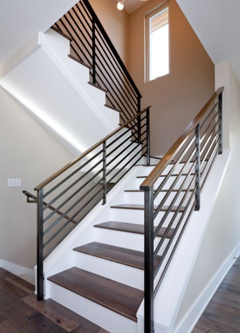 A simple and stylish way to make the staircase look simple yet chic and eye-catching is to use contrasts. In this case, for example, the wooden stairs sit on a crisp white background and the metal guardrail with wooden handrail frame them beautifully. Cotswold House, Metal Stair Railing, درج السلم, Modern Stair Railing, Metal Handrails, Case In Pietra, White Stairs, Handrail Design, Contemporary Staircase