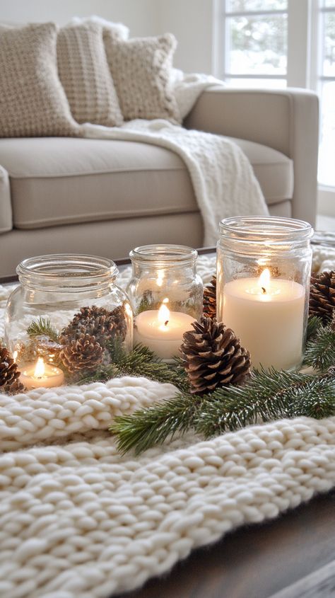 Cozy coffee table with a white knit blanket, candles, pine cones, and evergreen branches in a warm, inviting living room setting. Cozy Christmas Bedroom Aesthetic, Cream Colored Sofa, Winter Living Room Decor, Winter Decor Ideas, Table For Christmas, Cozy Winter Decor, Winter Living Room, Glass Dome Cloche, Winter Retreat