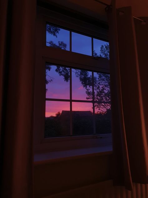 Blue, purple, and pink sunset through window, with silhouettes of trees and buildings. Sunsets From Window, Anime Evening Scenery, Window Sunset Painting, Sunset Window Aesthetic, Sunset Through Window, Purple Sunset Aesthetic, Sunsets Purple, Journey Collage, Pink And Blue Sunset