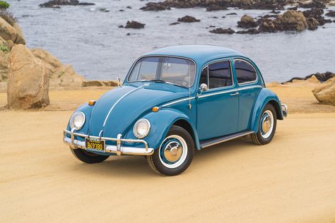 A 1966, blue Volkswagen Beetle, photographed with an ocean background with rocks and sand. Volkswagen Beetle, Volkswagen, Design