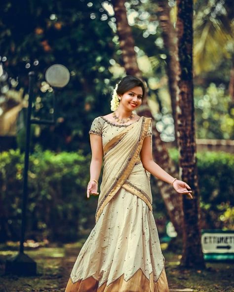 In a beautiful bridal outfit with boat neck blouse design Dawani Designs Kerala Style, Dhavani Set New Model, Malayali Saree, Kerala Engagement Dress, Kerala Wedding Saree, Kerala Saree Blouse, Onam Outfits, Kerala Saree Blouse Designs, Half Saree Lehenga