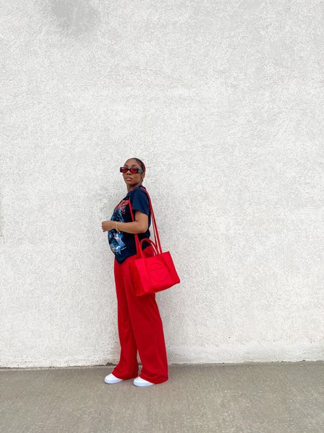 black girl in ice cube red and blue graphic tee, red sweatpants, air force 1s, red telfar bag Outfit With Air Force, Outfit With Air Force 1, Red Telfar Bag, Outfits With Air Forces, Streetwear Outfit Black, Girl Casual Outfits, Girl Streetwear Outfit, Red Sweatpants, Big Tote Bags