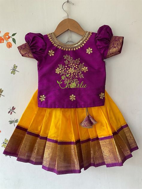 Traditional Kanchipuram silk skirt and raw silk top - yellow pavadai with maggam work purple top. BUYER'S PLEASE LEAVE YOUR CONTACT NUMBER. It's necessary for shipping. Leave message in the buyer note about the age of kid . Fabric and Work: Top: . Fabric used is raw silk and is embellished with maggam work. The dress is lined with soft cotton fabric. The top has hook opening at back side of the dress. Skirt: Kanchipuram silk fabric with purple jacquard boarder and also lined with a cotton fabric Pattu Pavadai Kids Blouse Designs, Pattu Pavadai Designs, Pattu Pavadai, Kids Dress Collection, Kids Blouse Designs, Kids Lehenga, Kids Blouse, Kids Dress Patterns, Baby Dress Design