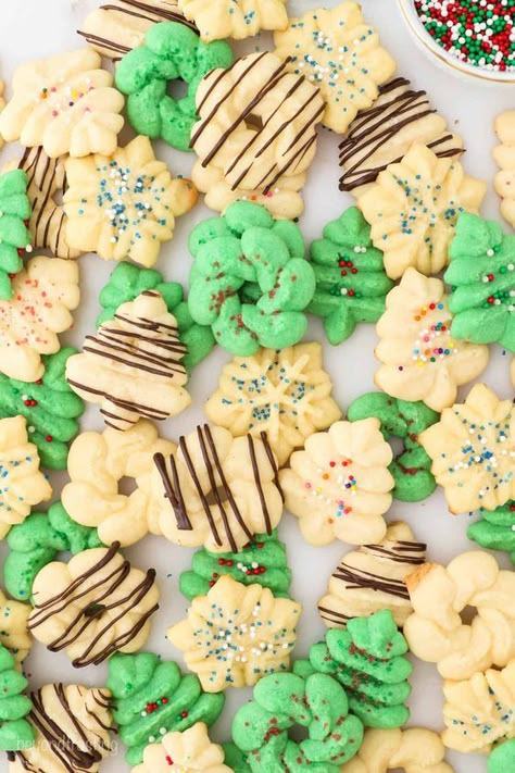 These beautiful little Spritz Cookies are so easy to make with just 6 ingredients! There are tons of tasty flavor options and fun ways to decorate these soft and buttery holiday treats. Decorating Spritz Cookies, Sprits Cookie Recipe, Wilton Spritz Cookie Recipe, Lemon Spritz Cookies, Spritzer Cookies, Buttery Spritz Cookies, Spritz Cookie Press, Cream Cheese Spritz Cookies, Butter Spritz Cookies