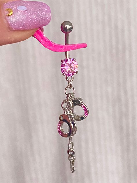 Dangly Pink Handcuff Belly Ring Details : Metal : 316L Stainless Steel Length: 2.2 inches Available in White and Pink Sold as a single piece. *for safety and hygienic precautions, body jewelry cannot be returned* Arm Piercing, Pink Handcuffs, Bellybutton Piercings, Belly Button Piercing Jewelry, Belly Piercing Jewelry, Grunge Jewelry, Belly Button Jewelry, Cool Piercings, Cute Piercings