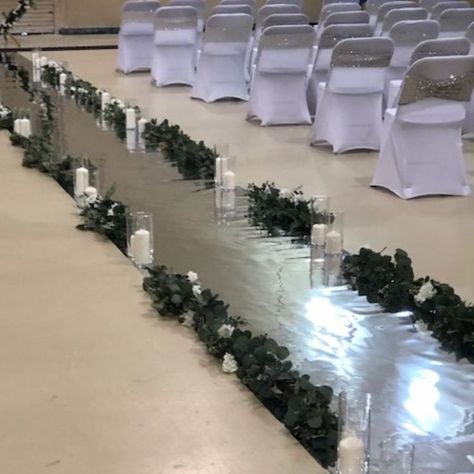 This beautiful runway will make any bride feel like a the star of the day that she is. Appear to walk on water with this mirrored aisle runner lined with beautiful greenery and glass cyliners and white candles. #ceremony #weddingdreams #weddingceremony #weddingaisle #weddingaisledecor #weddingdecor #nuptuals #ido #bride #groom #love #weddingvenue Candles Ceremony, Mirrored Aisle, Wedding Aisle Decor, Event Layout, Aisle Runner Wedding, Wedding Renewal Vows, Star Of The Day, Dream Wedding Decorations, Wedding Aisle Decorations