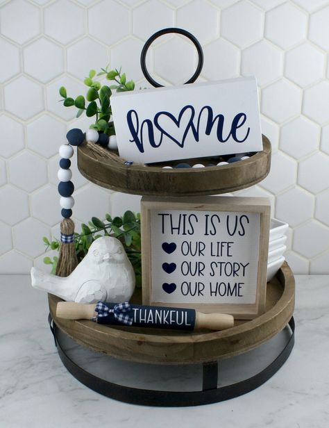 "EACH PIECE IS SOLD SEPARATELY Individual details: HOME (with heart) self-standing wood sign, painted matte white with navy blue vinyl lettering, measures 2 3/4\" tall x 5 1/2\" wide x 3/4\" thick THIS IS US self-standing wood sign, background is matte white with navy blue vinyl lettering, measures 5\" square x 1\" thick Beaded garland, made with hand painted navy blue and matte white wood beads with twine tassels that have blue & white plaid accent ribbons, measures 22 inches long Tray, greener White Tiered Tray, Wood Tray Decor, Classy Room, Navy Blue Decor, Classy Rooms, Table Centerpieces For Home, White Kitchen Decor, Rustic Blue, Home Decor Accents