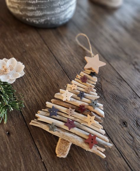 Rustic Christmas tree ornament made from driftwood and popsicle stick with wood star embellishments and twine around the tree stump Recycled Tree Craft, Christmas Tree With Sticks, Driftwood Christmas Trees, Nature Christmas Tree Decorations, Driftwood Christmas Crafts, Driftwood Ornaments Diy, Christmas Driftwood Ideas, Christmas Tree From Branches, Stick Ornaments Diy