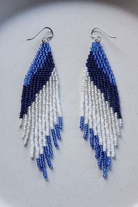 Modern hand woven seed bead brick stitch and fringe dangling earrings in a cascading color pattern inspired by nature’s icescapes. A sparkling winter wonderland; majestic blues, silver crystal and snow white. Beaded Earrings Patterns Free, Seed Bead Brick Stitch, Bead Brick Stitch, Ice Hockey Stick, Seed Bead Fringe Earrings, Bead Fringe Earrings, Beaded Fringe Earrings, Beading Crafts, Seed Beading