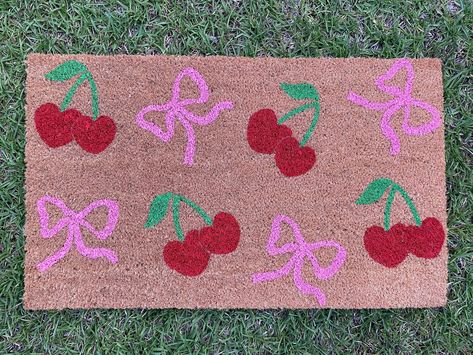 Cherry and Bow Doormat Our doormats make great gifts for holidays, housewarmings, anniversaries, birthdays, weddings, or just because! Our doormats are made of 100% natural coir and have a slip-resistant vinyl backing. All doormats are hand-painted with weather-resistant paint and sealed with a UV protectant spray. All of our doormat designs can be personalized! Want to change the color or add your name? Send us a message on Etsy or a DM us on Instagram to get started! Our Instagram account is @ Doormat Diy Ideas, Painted Front Door Mat, Paint A Doormat, Doormat Painting Ideas, Door Mat Painting Diy, Diy Doormat Paint, Diy Painted Doormat, Doormat Ideas Funny, Painted Door Mat