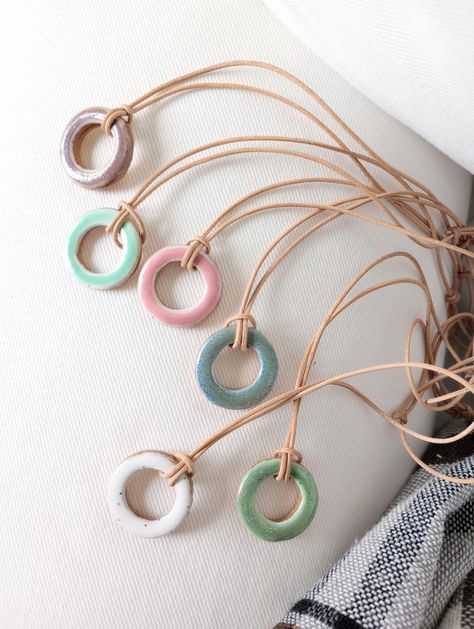 "Sweet little ceramic open circle necklaces to brighten your day with a little pop of color :)  These one of a kind, earthy-minimalist, o-ring shaped necklaces are made with reclaimed/recycled, stoneware speckled clay and make for a lovely and original gift to give to yourself or a special friend. Use as a necklace or passive essential oil diffuser in your car/home/office! This elegant and minimalist style ceramic pendant, hangs on an adjustable slide-knot leather cord and features an unglazed s Earthy Minimalist, Circle Necklaces, Ceramic Pendants, Handmade Ceramic Jewelry, Speckled Clay, Ceramic Necklace, Ring Der O, Car Home, Earrings Inspiration