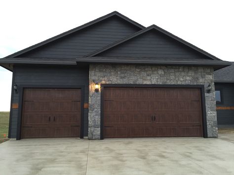 Clopay walnut garage doors with accent handles. Dark Exterior House Colors, Blue Home Exterior, Dark Exterior House, Grey Garage Doors, Brown Garage Door, Black Garage Doors, Exterior Siding Colors, Garage Door Types, Ranch House Exterior