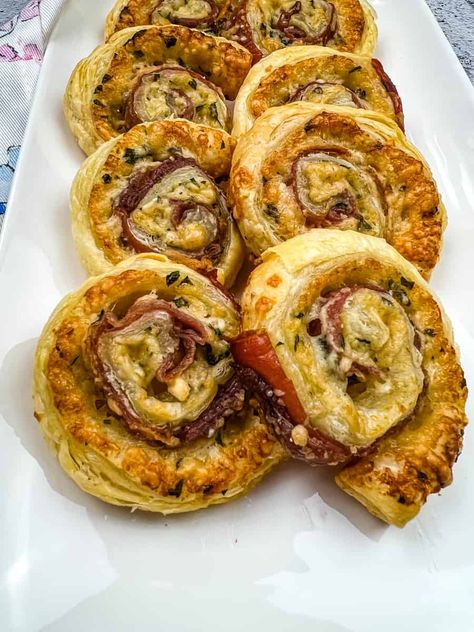 prosciutto and parmesan pinwheels on a platter Puff Pastry Appetizers Proscuitto, Puff Pastry Prosciutto, Pesto Pinwheel Appetizers, Prosciutto Roll Ups, Fall Pinwheel Recipes, Baked Pinwheel Recipes, Goat Cheese Pinwheels, Recipes Using Puff Pastry Sheets, Parmesan Puff Pastry