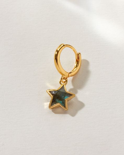 Featuring a unique star-shaped gemstone cradled in a golden embrace, this earring dangles from a huggie hoop, offering more than just ornamentation—it's a call to express your distinct style. A versatile addition to any collection, it empowers you to mix, match, and stack, crafting a look that's entirely your own. It's the perfect piece for those who draw inspiration from the celestial wonders above or the marine mystery below. Star Shaped Things, Queer Earrings, Earring Brands, Cool Earrings Unique, Thrift Fit, Earring Stacks, 2024 Aesthetic, Vintage Gold Earrings, Ear Style