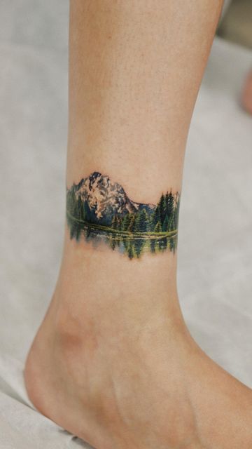 Mountain Range Ankle Tattoo, Mountain Tattoo Colorful, Mountain Arm Band Tattoo For Women, Negative Space Tattoo Women, Large Mountain Tattoo, Watercolor Landscape Tattoo, Pnw Inspired Tattoo, Mountains And Water Tattoo, Colored Mountain Tattoo