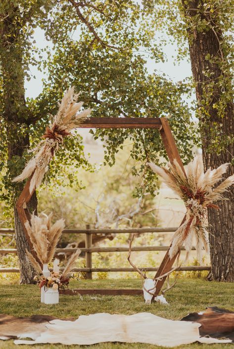 Octagon wedding arch with pampas grass. Western boho wedding, Boho-glam, modern bride, boho wedding, western wedding Pampas Grass Arch Decor, Deer Horn Wedding Arch, Alter Backdrop Wedding Outdoor, Boho Arbor Floral Arrangement, Wedding Octagon Arch Flowers, Pompous Grass Wedding Arch, Pampas Arch Wedding, Boho Western Wedding Arch, June Boho Wedding