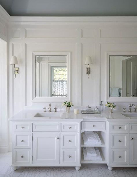 Under a dark gray ceiling, bright white bathroom walls with white millwork are lit by Waterworks Blue Note Sconces and hold white beveled mirrors over a white dual bath vanity. All White Bathroom, Grey Ceiling, White Bathroom Designs, Serene Bathroom, Recessed Medicine Cabinet, Double Sinks, Bad Inspiration, Master Bath Remodel, Cabinetry Design