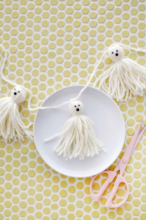 Tassel Ghost Garland Diy, Diy Halloween Garland For Kids, Ghost Garland Yarn, Halloween Crafts With Yarn, Halloween Tassel Garland, Ghost Pom Pom, Diy Ghost Garland Yarn, Fall Crafts With Yarn, Ghost Tassel Garland