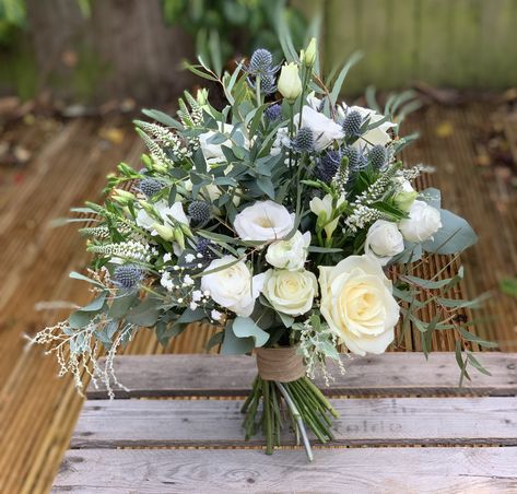 Wedding bouquet of eucalyptus, white roses and blue thistle with hessian ribbon Wedding Flowers With Blue Thistle, Fresh Flowers Wedding Bouquet, Bouquets With Thistle, Rosemary And Eucalyptus Wedding, Hydrangea And Thistle Bouquet, White And Thistle Wedding Flowers, Bridal Bouquet Eucalyptus White, Wedding Bouquets With Thistles, Thistle Wedding Centerpieces