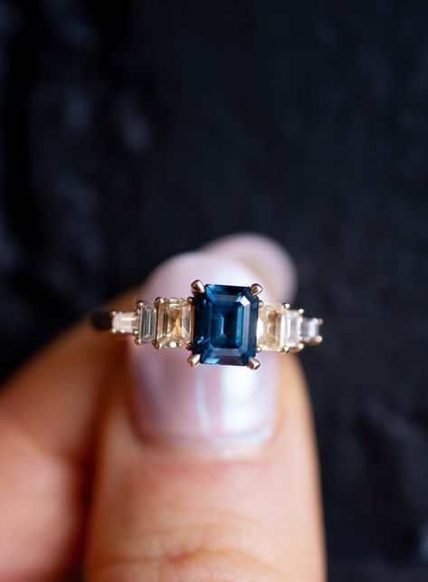 This custom emerald cut sapphire and diamond baguette engagement ring was designed for a client who met her fiancé on Sapphire Street. Accordingly, it was symbolic to include sapphire as the main stones in her engagement ring, dark blue for her center stone, and yellow sapphires because her favorite color is yellow. Wanting with an estate jewelry feel, we prong set baguette diamonds in descending order from the sapphire center stone, creating a silhouette with antique influences. #engagementring Sapphire And Baguette Diamond Ring, Safire Rings, Emerald Cut Sapphire Ring, Sapphire And Diamond Engagement Ring, Baguette Engagement Ring, Engagement And Wedding Ring, Wedding Ring Ideas, Diamond Baguette, Engagement Ring Ideas