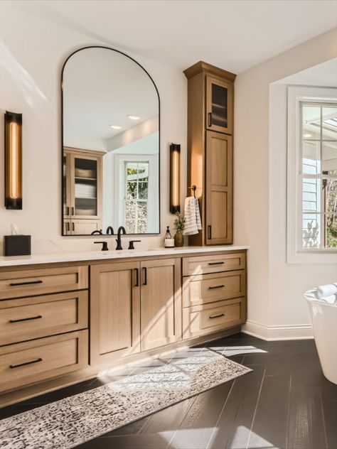 Go to the link to see more of this stunning primary bathroom remodel. This custom vanity was built for beauty and tons of storage. Long arched mirrors and linear sconces. Black matte plumbing fixtures. Open glass doors on the top cabinets to display decor. Modern Scandinavian style. Black wood herringbone tile floors. Oak Vanity Bathroom, Modern Vanity Lights, White Oak Vanity, Herringbone Tile Floors, Oak Bathroom, Beautiful Sunday, Wood Bathroom Vanity, Quarter Sawn White Oak, Extension Ideas